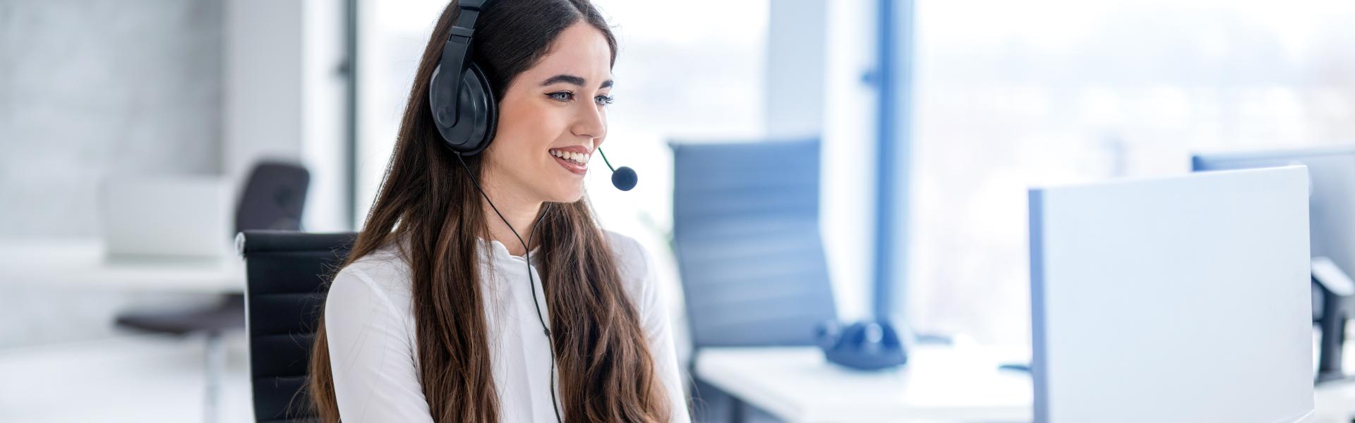 Lächelnder Callcenter-Agent, der am Helpdesk arbeitet, die Kommunikation von Kunden verfolgt, überwacht und beantwortet.