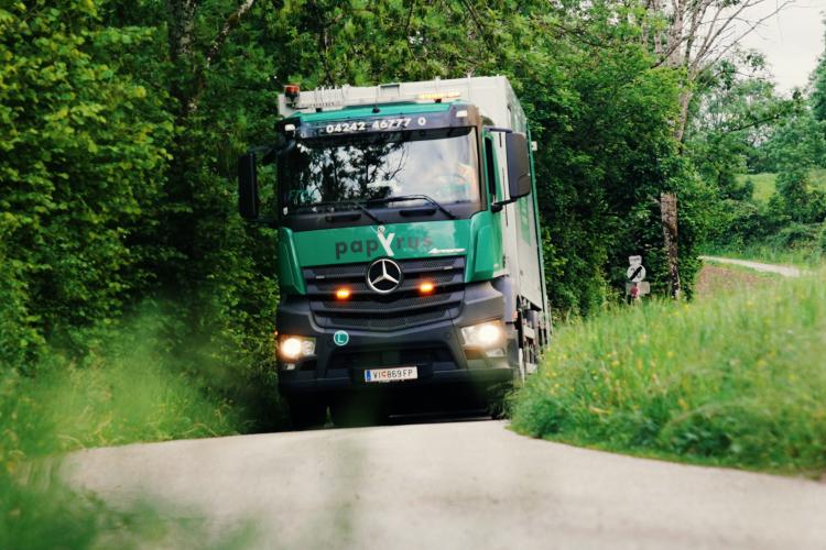 Press LKW fährt auf Landstraße im Grünen